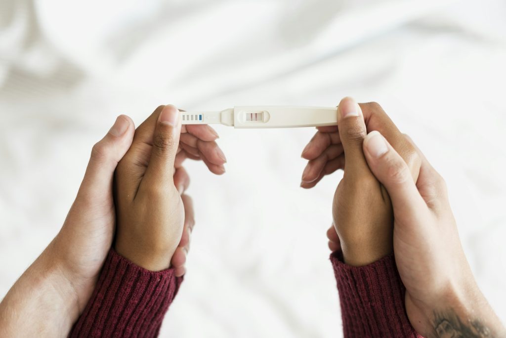 Pregnancy announcement in hands holding hands